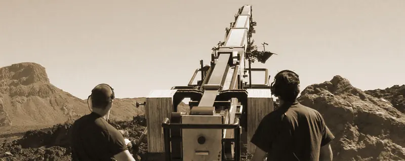 Crew filming with a camera crane in a desert landscape